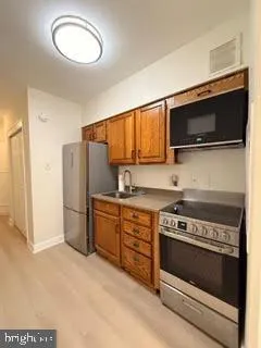 a kitchen with stainless steel appliances a stove microwave and refrigerator