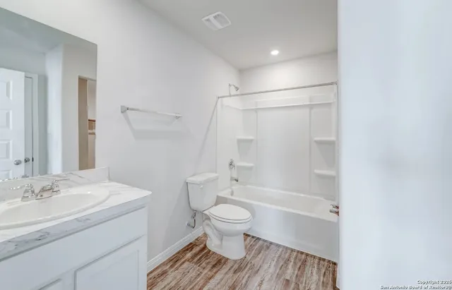 a bathroom with a sink a toilet and a large mirror