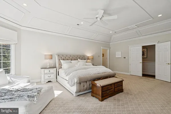 a spacious bedroom with a bed mirror and window
