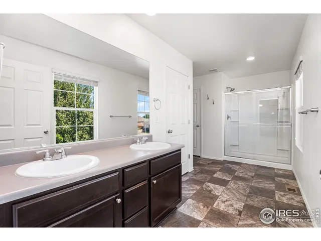 a bathroom with a sink shower and a mirror
