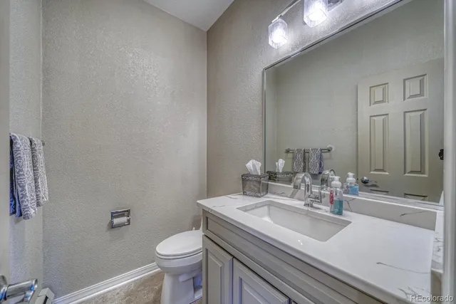 a bathroom with a sink toilet and a mirror