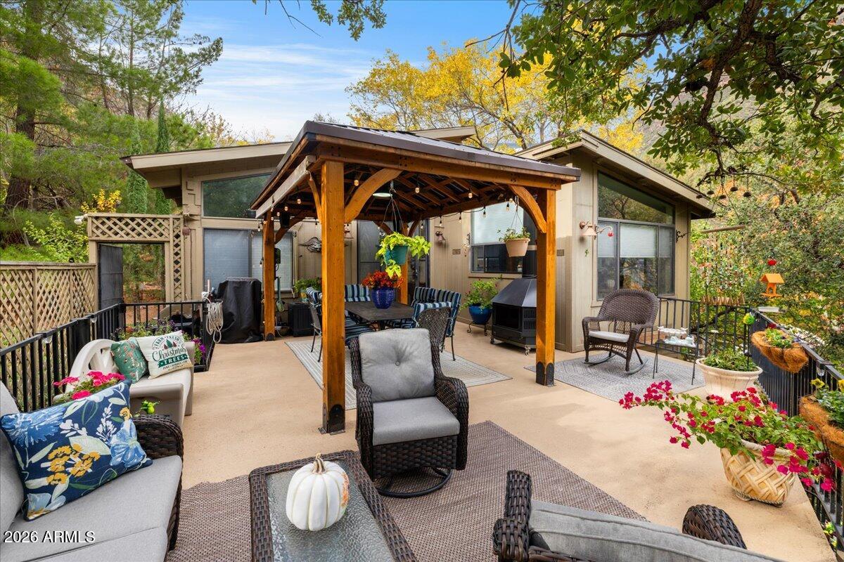 4426 North State Rte 89A, Unit 13 Sedona, AZ 86336 - Photo 31 of 47 a view of a patio with table and chairs potted plants and a large tree