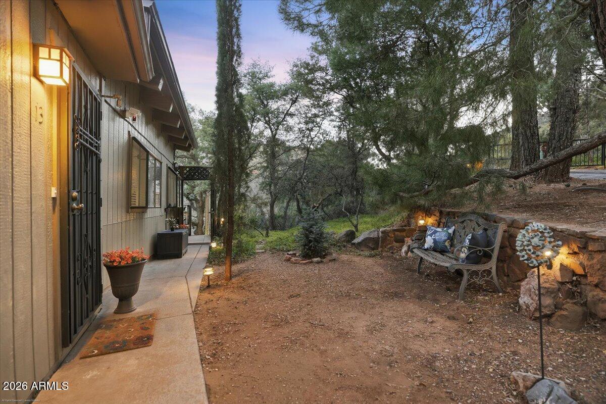 4426 North State Rte 89A, Unit 13 Sedona, AZ 86336 - Photo 8 of 47 a view of a patio with table and chairs and couches with wooden fence and floor
