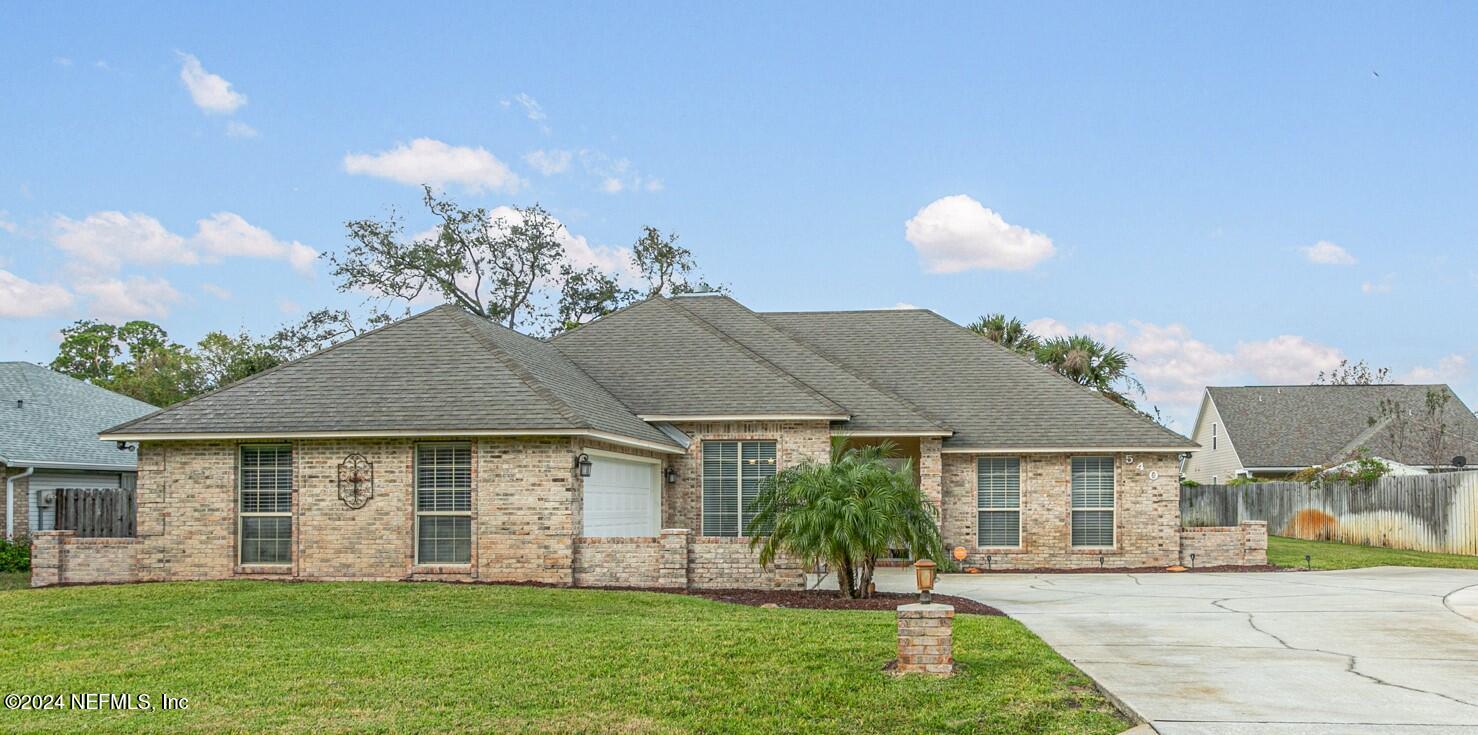 a front view of a house with a garden and plants