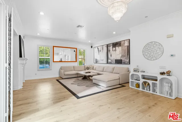 a living room with furniture a large window and stainless steel appliances