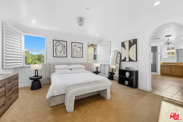 a spacious bedroom with a bed and dresser