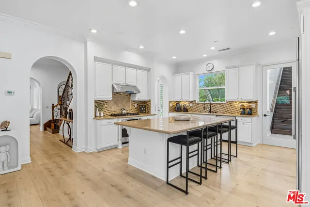 a kitchen with stainless steel appliances granite countertop a table and chairs
