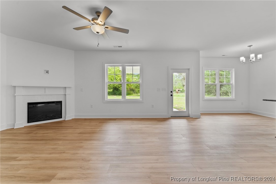 2902 Calloway (lot 1) Road Raeford, NC 28376 - Photo 17 of 44 an empty room with windows fireplace and a ceiling fan
