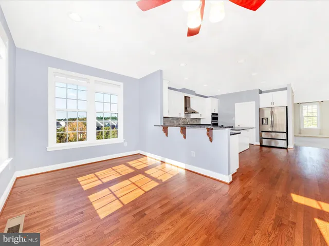 a kitchen with stainless steel appliances a refrigerator and wooden floor