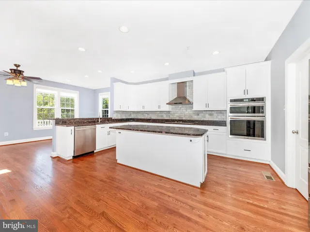 a kitchen with granite countertop a stove and wooden floor