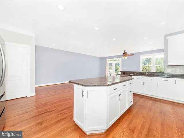 an empty room with windows and ceiling fan
