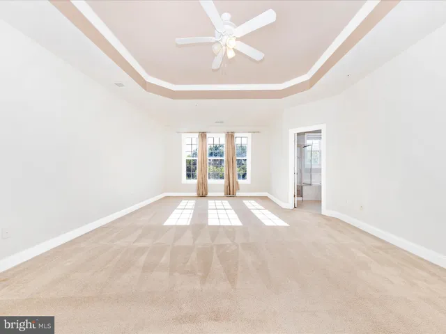 a view of a big room with windows and chandelier fan