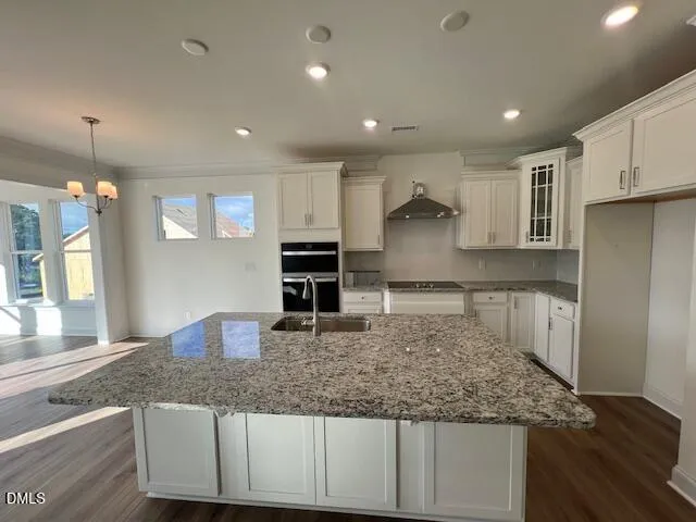 a open kitchen with kitchen island a stove a sink and a refrigerator