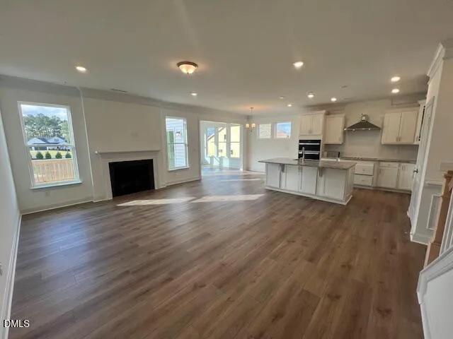 a view of empty room with wooden floor and fireplace