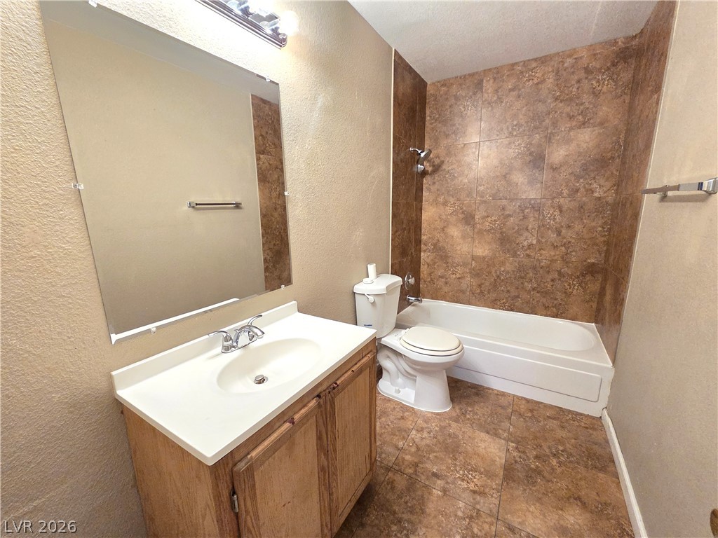 2882 Sandyfalls Way Las Vegas, NV 89142 - Photo 14 of 18 A well-appointed bathroom features a single vanity, a spacious mirror, and a combined tub and shower area.