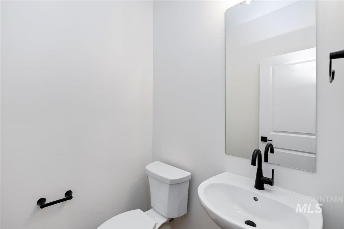 752 South Calhoun Lane Star, ID 83669 - Photo 31 of 45 Modern powder room with a white wall-mounted basin, matte black faucet, and rectangular mirror