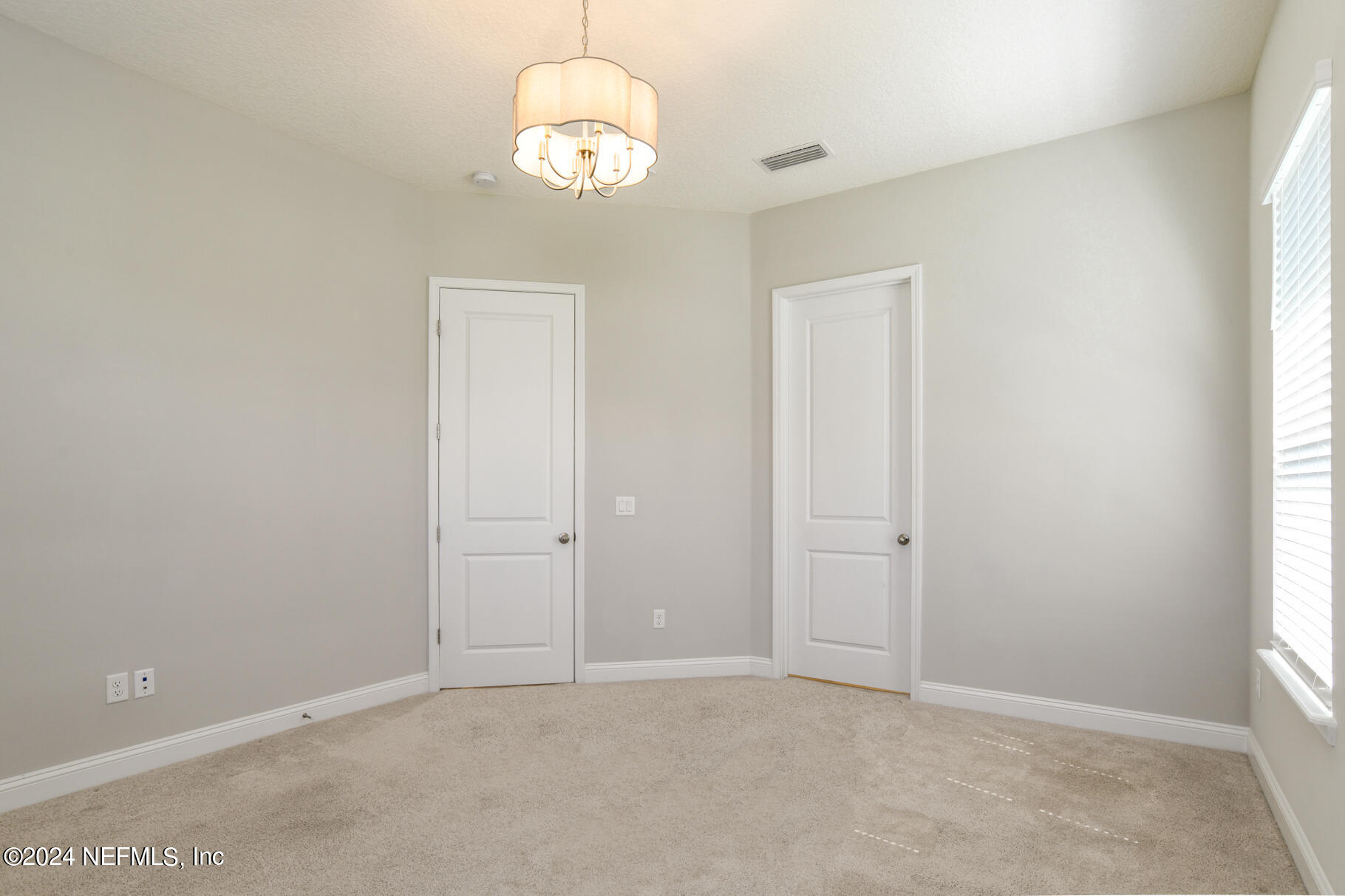 405 Pintoresco Drive St. Augustine, FL 32095 - Photo 34 of 51 an empty room with a chandelier fan and window
