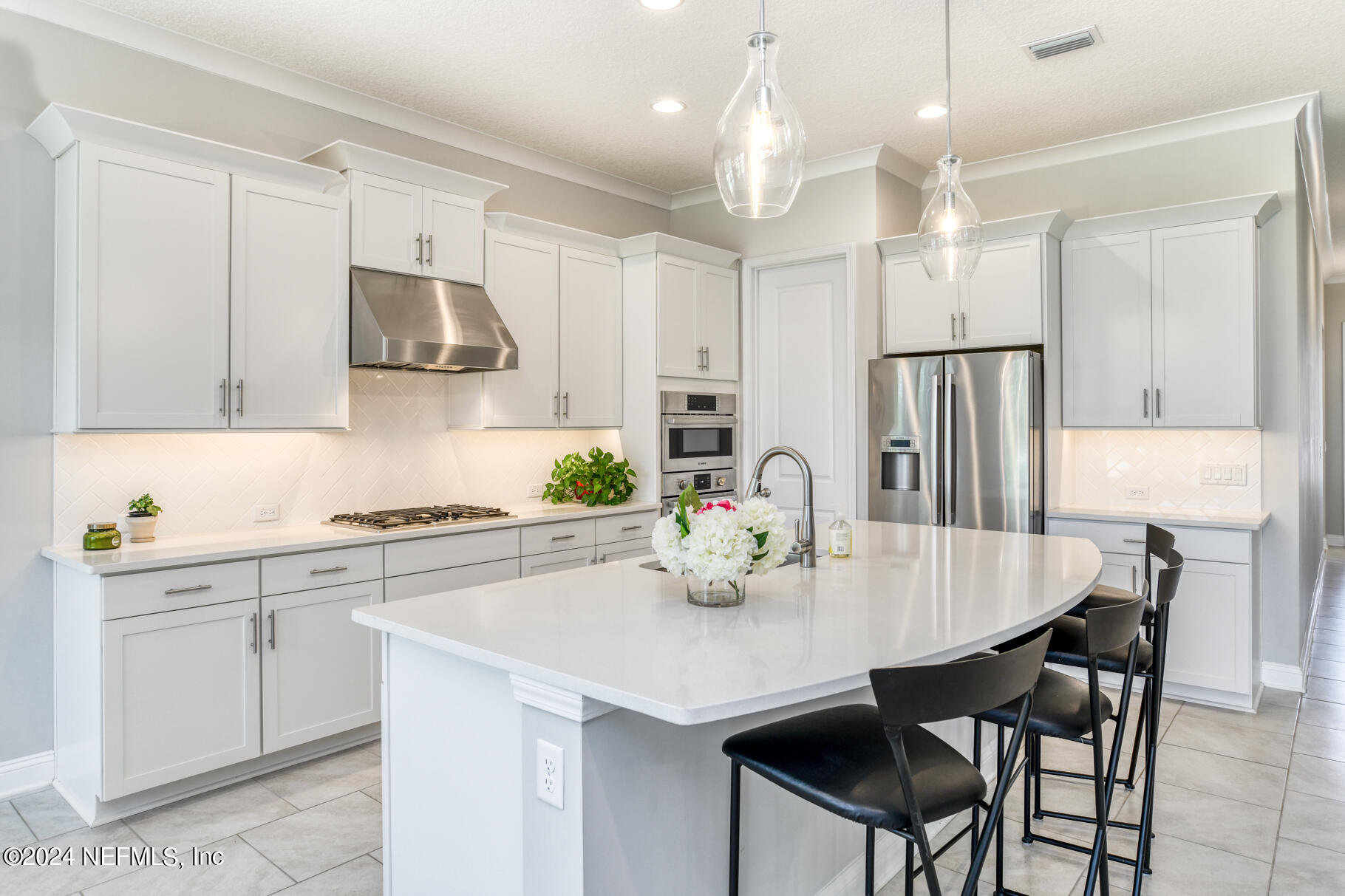 405 Pintoresco Drive St. Augustine, FL 32095 - Photo 9 of 51 a kitchen with stainless steel appliances a dining table chairs and white cabinets