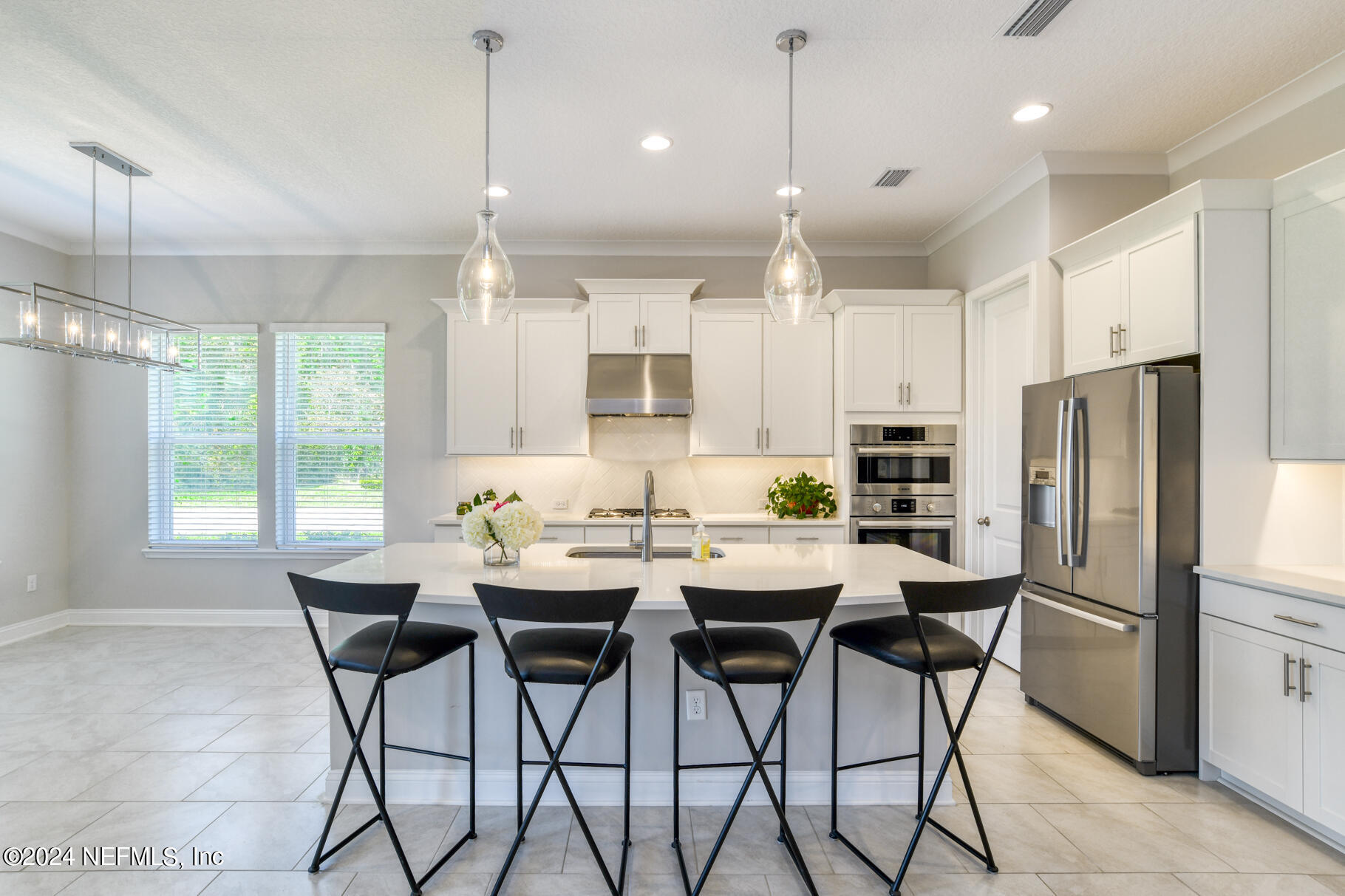 405 Pintoresco Drive St. Augustine, FL 32095 - Photo 10 of 51 a kitchen with stainless steel appliances kitchen island granite countertop a dining table chairs and white cabinets
