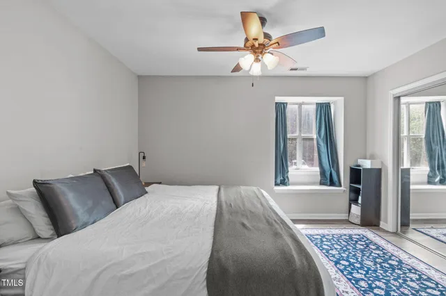 a bedroom with a bed and a ceiling fan