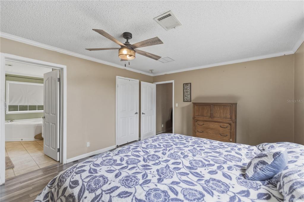 12400 Southeast 99th Terrace Belleview, FL 34420 - Photo 11 of 20 a bedroom with a bed and a chandelier