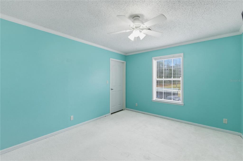 12400 Southeast 99th Terrace Belleview, FL 34420 - Photo 15 of 20 an empty room with chandelier fan and windows