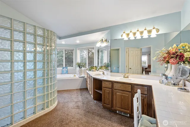 a spacious bathroom with a double vanity sink mirror and a bathtub