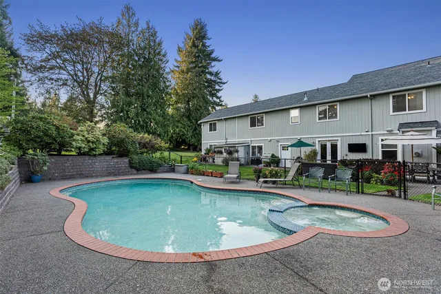 a view of a house with swimming pool and sitting area