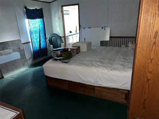 a bedroom with a bed window and mirror