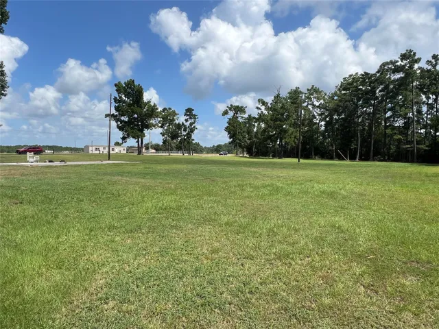 a view of a field with an trees in the background