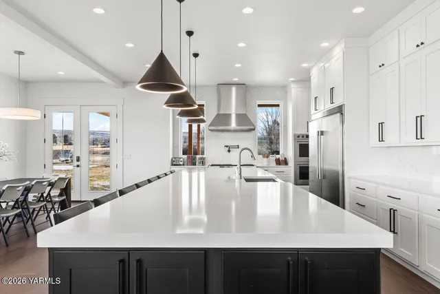 a kitchen with stainless steel appliances granite countertop a lot of cabinets
