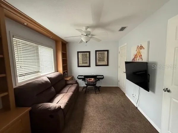 a living room with furniture a flat screen tv and a window