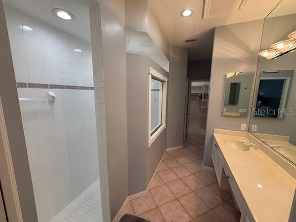 a large bathroom with a tub sink and mirror