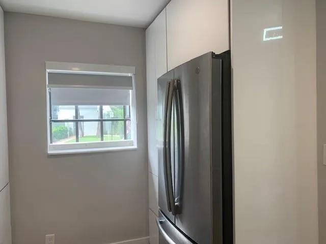 a metallic refrigerator freezer sitting inside of a kitchen