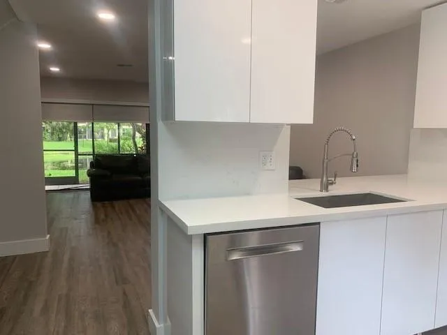 a kitchen with a sink cabinets and wooden floor