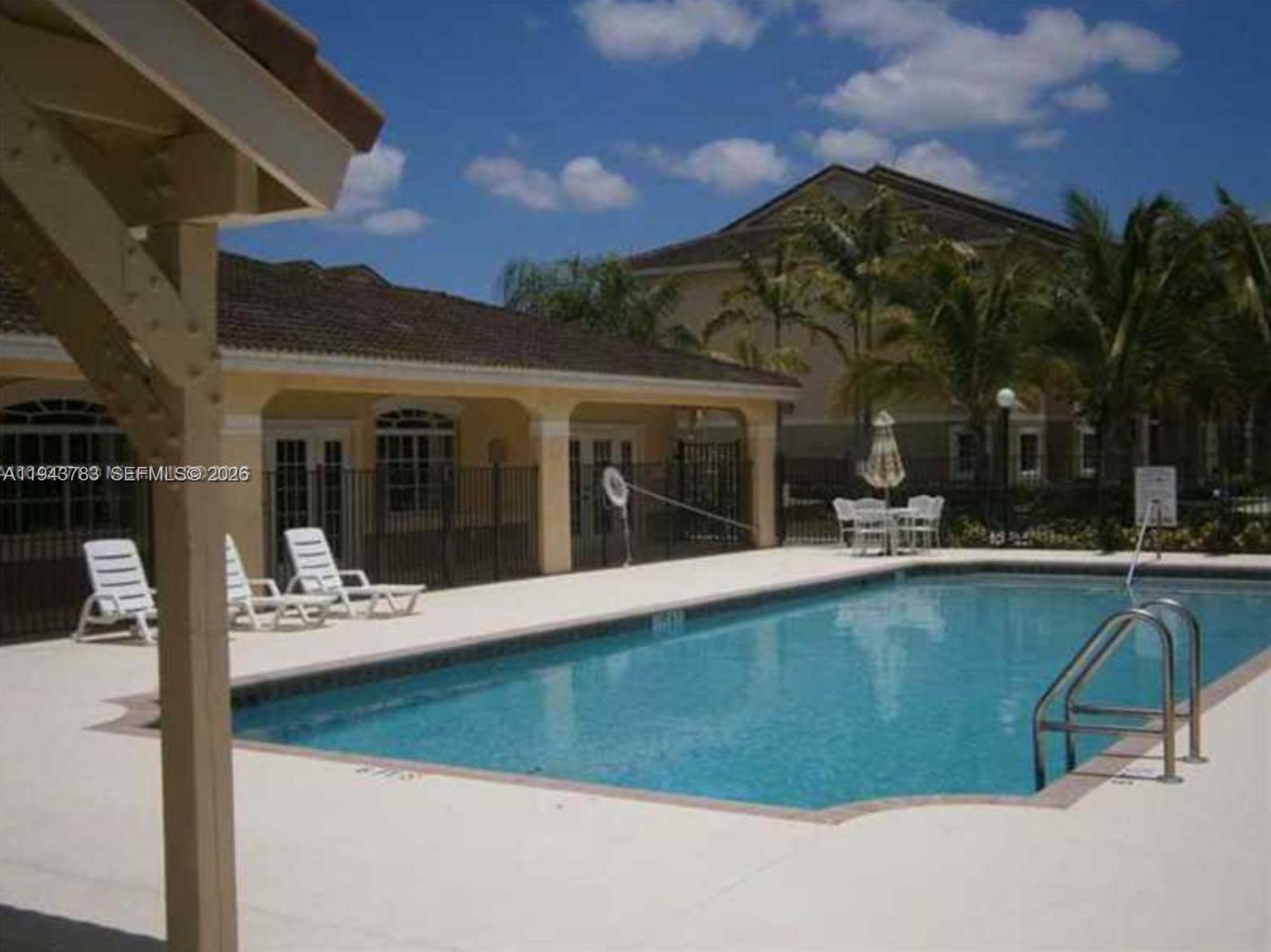 15480 Southwest 284th Street, Unit 2304 Homestead, FL 33033 - Photo 26 of 31 a view of a building with a swimming pool and sitting area