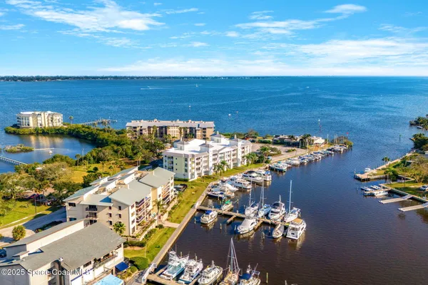 an aerial view of ocean and residential houses with outdoor space
