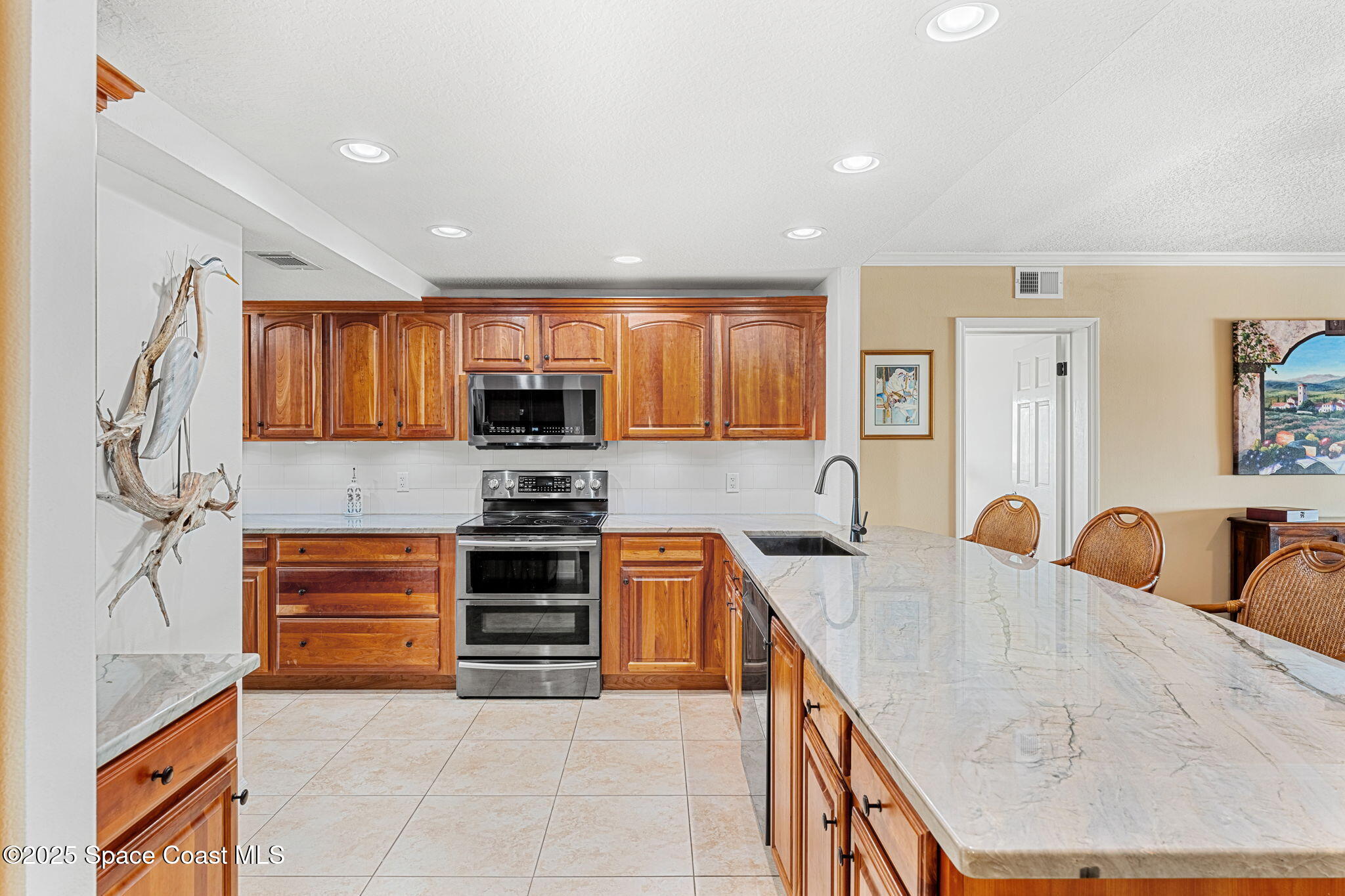 2220 Front Street, Unit 404 Melbourne, FL 32901 - Photo 9 of 51 a kitchen with stainless steel appliances granite countertop wooden cabinets a stove top oven a sink and dishwasher