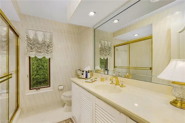 a bathroom with a sink a toilet and a large mirror