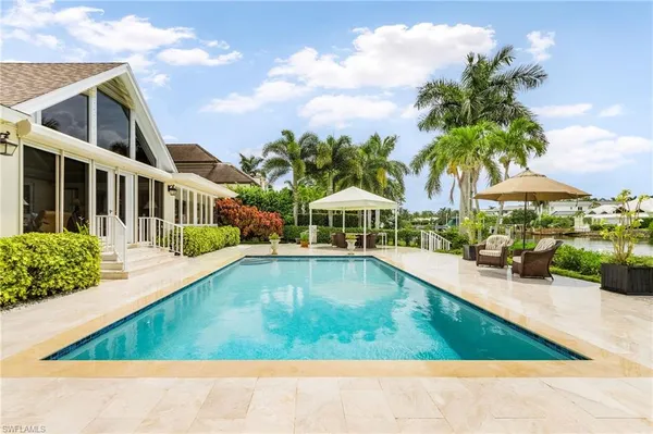 a view of swimming pool with outdoor seating and a garden