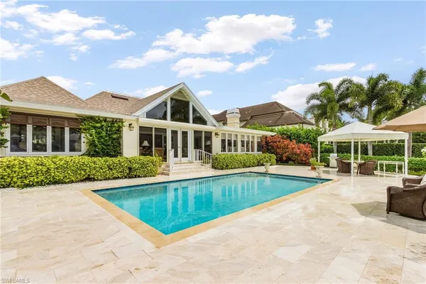 a view of a house with swimming pool and sitting area