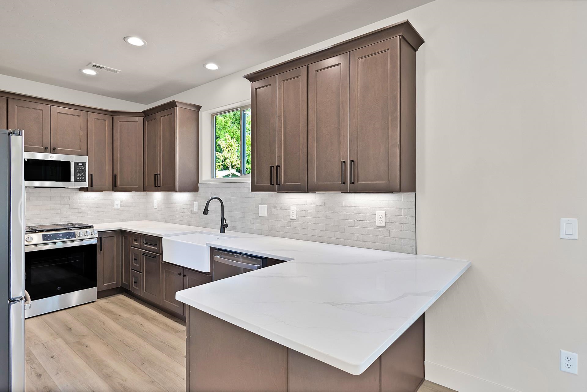 1111 Sprocket Court Fruita, CO 81521 - Photo 13 of 41 a kitchen with stainless steel appliances a sink a stove a refrigerator a microwave and cabinets