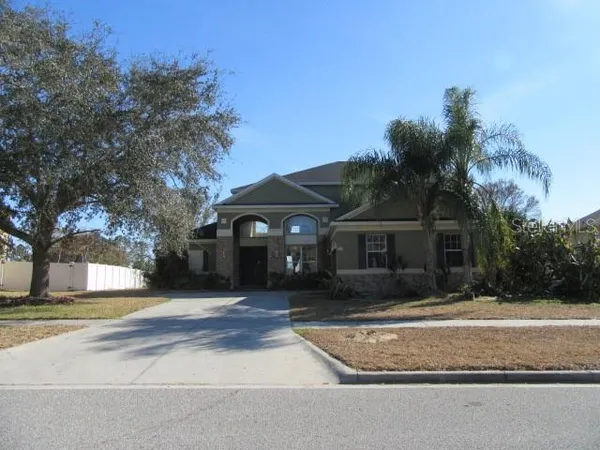 a front view of a house with a yard and trees