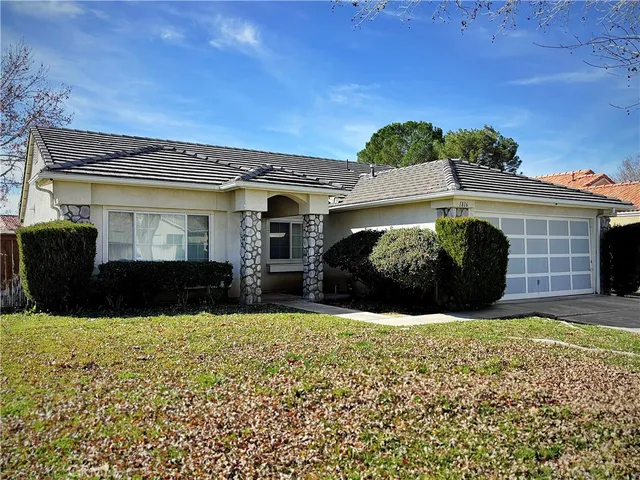 a view of house and yard with large trees