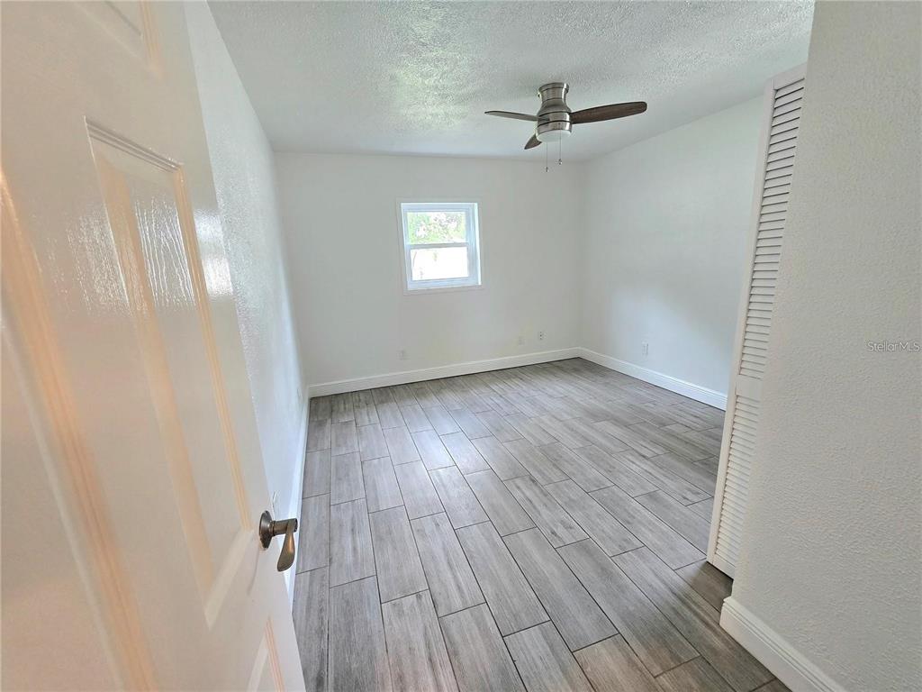 812 High Street Orlando, FL 32803 - Photo 11 of 15 an empty room with wooden floor fan and windows