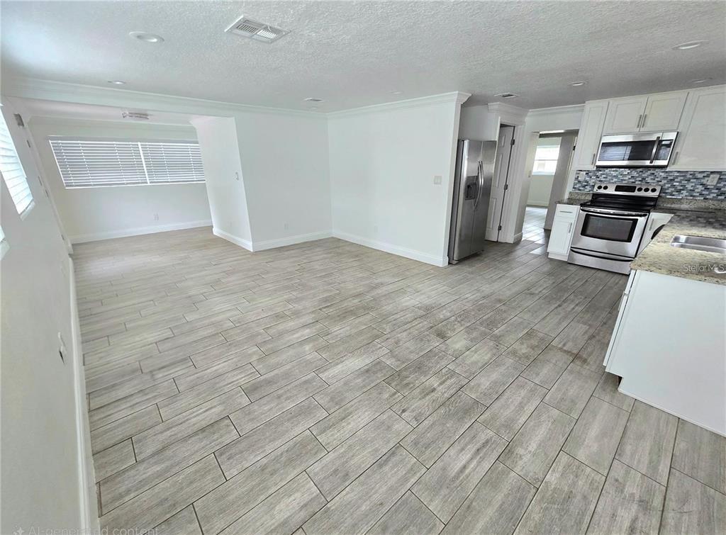 812 High Street Orlando, FL 32803 - Photo 3 of 15 an empty room with wooden floor steel appliances and windows