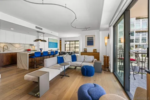 a living room with furniture kitchen view and a large window