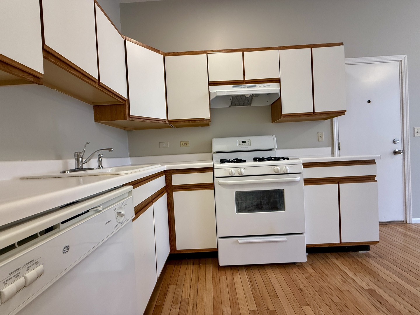 556 West 37th Street, Unit 3F Chicago, IL 60609 - Photo 2 of 12 a kitchen with granite countertop wooden floors and white stainless steel appliances