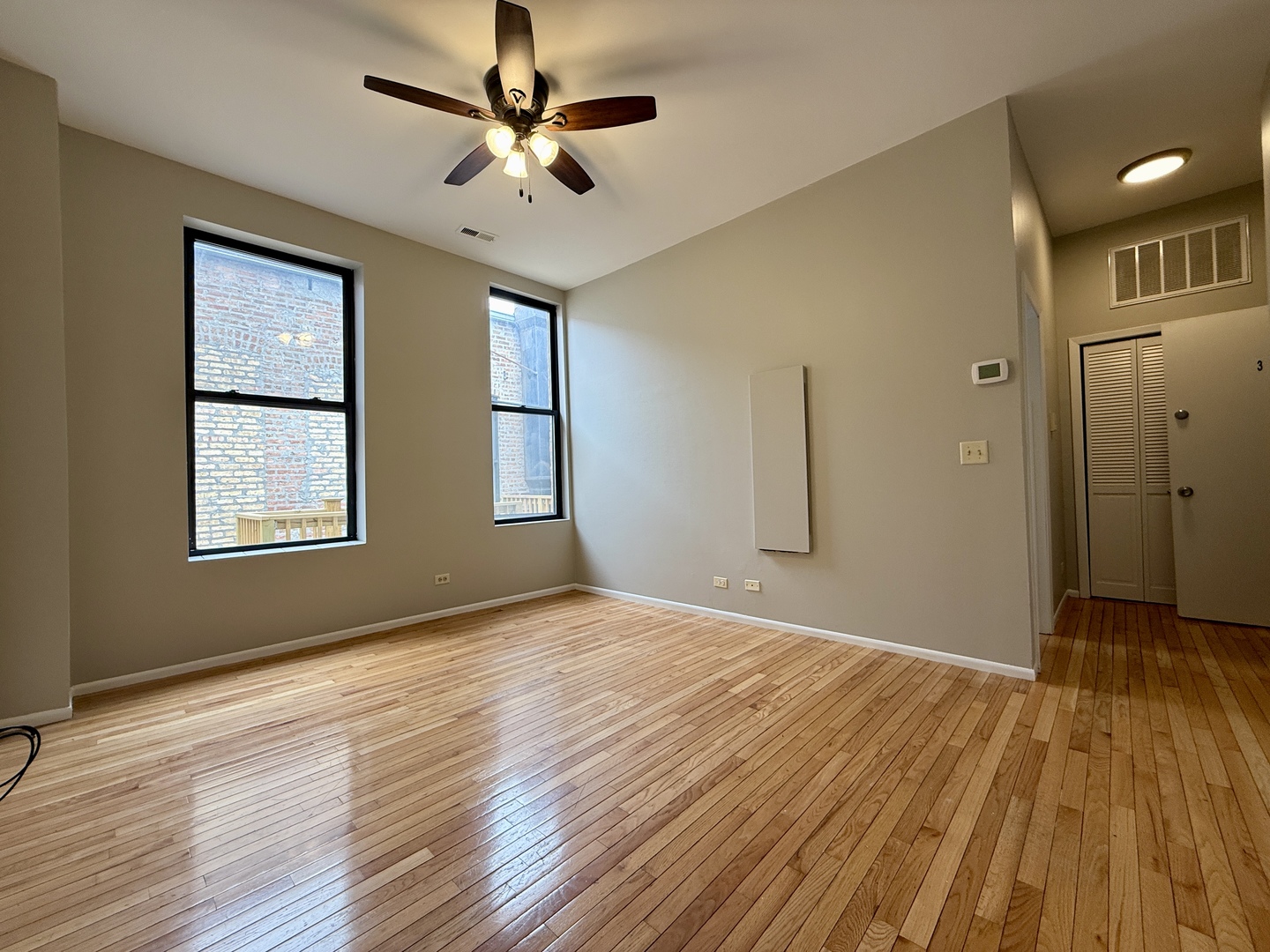 556 West 37th Street, Unit 3F Chicago, IL 60609 - Photo 7 of 12 a view of an empty room with wooden floor and a window