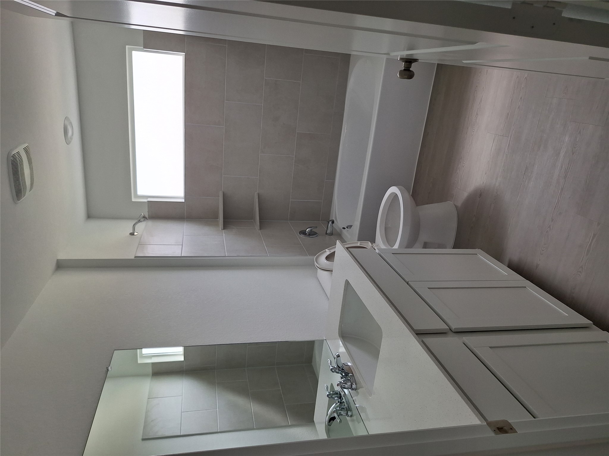 18001 Prairie Falcon Way Pflugerville, TX 78660 - Photo 10 of 38 Bathroom featuring a single vanity with an integrated sink and light-toned countertop, a white bathtub with a shower, and light gray wall tiling